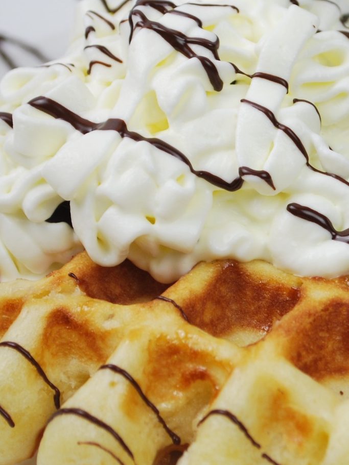 Gofre recién hecho cubierto de nata y chocolate en Cafetería Patry de Urda