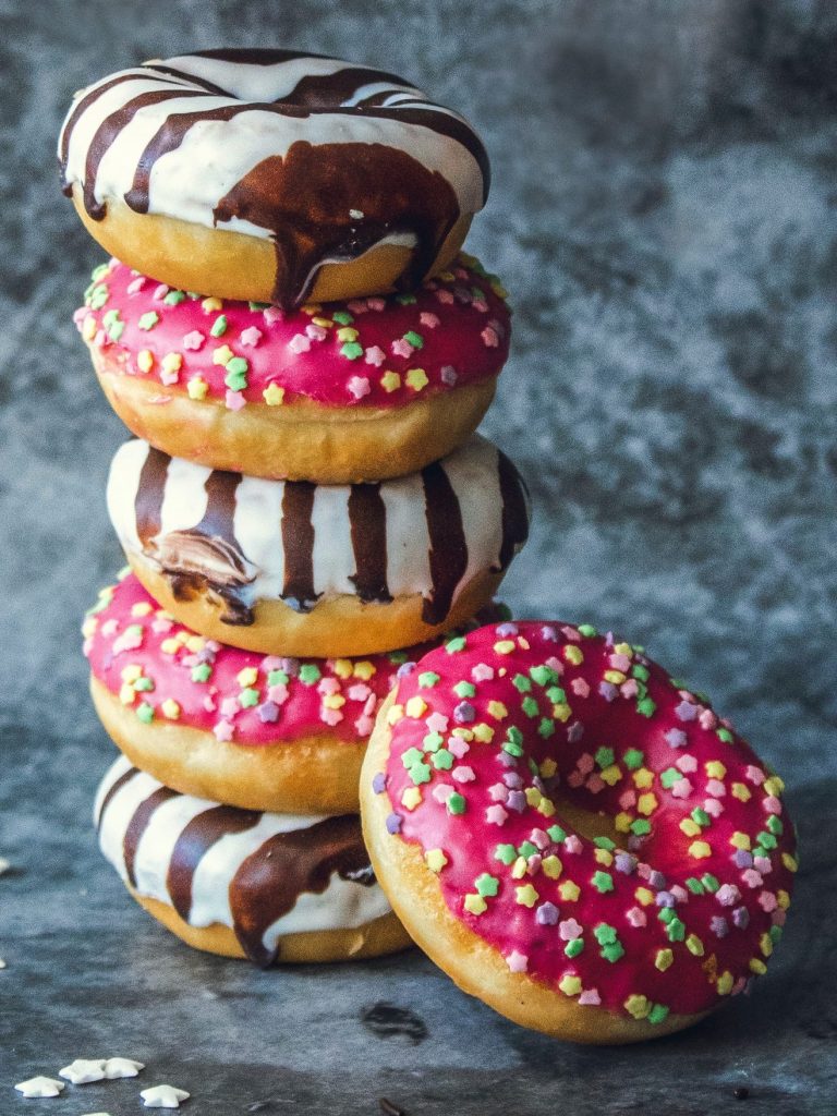 Varios donuts cubiertos con chocolates y crema de fresa